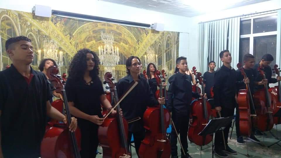 Orquestra infantil toca música em piano de instrumento escolar e