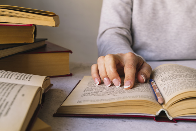 pessoa-estudando-ao-lado-da-pilha-de-livro_23-2147978228